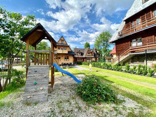 a playground with a slide in front of a house at Domki Vika Home i Wataha Home - świetna lokalizacja w centrum Zakopanego - 10min pieszo do Krupówek! in Zakopane