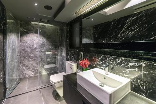 a bathroom with a white sink and a toilet at Hotel Pravo Hong Kong in Hong Kong