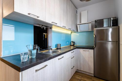 a kitchen with a sink and a refrigerator at Victus Apartamenty, Apartament Livia in Sopot
