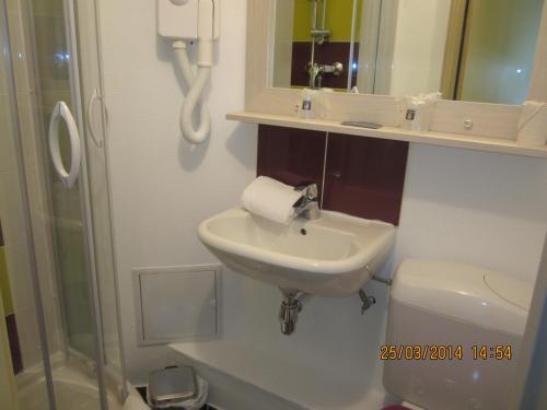 a bathroom with a sink and a toilet and a shower at Comfort Hotel Orléans Olivet in Olivet