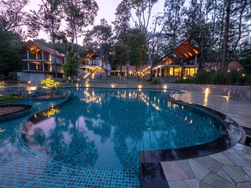 a swimming pool in a resort at night at The Birchwood Retreat, Madikeri in Madikeri