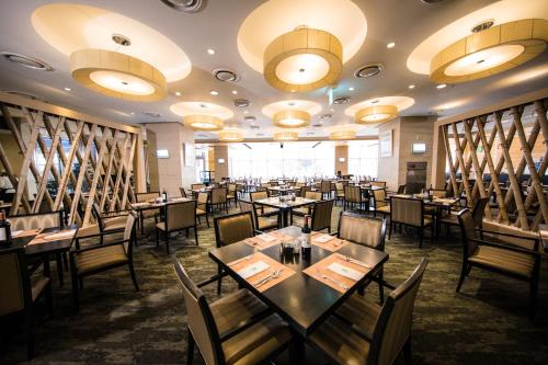 una sala da pranzo con tavoli, sedie e luci di Holiday Inn Gwangju, an IHG Hotel a Gwangju