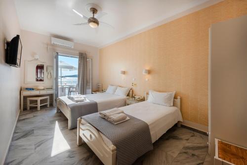 a hotel room with two beds and a table at Irene Studios - Beachfront in Parikia