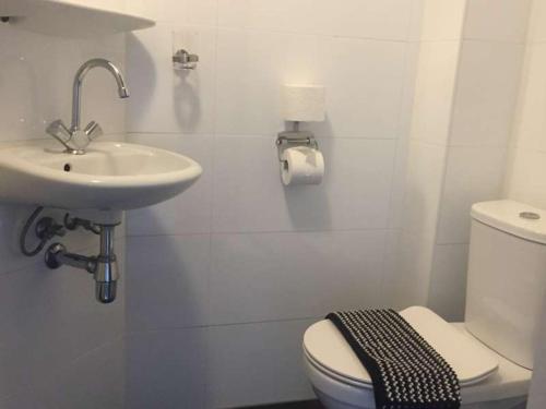 a white bathroom with a sink and a toilet at Hotel Verdi in Amsterdam