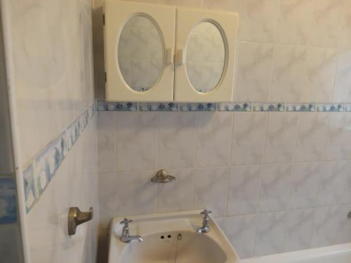 un bagno con due specchi sopra un lavandino di Dante Guest house ad Alberton