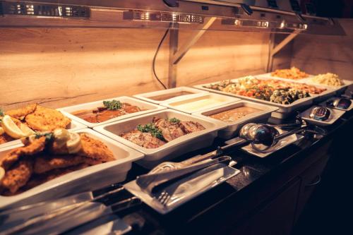 a buffet with many trays of food on a table at Hotel Zum Mühlental in Buch