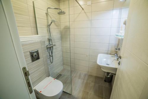 a bathroom with a shower and a toilet and a sink at Hotel River in Bijeljina