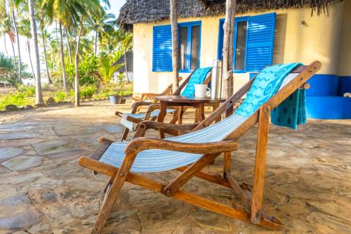a group of chairs sitting in front of a house at Hibiscus Beach House in Pangani
