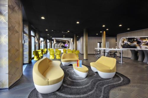 a waiting room with yellow chairs and a table at Prize by Radisson, Erfurt City in Erfurt