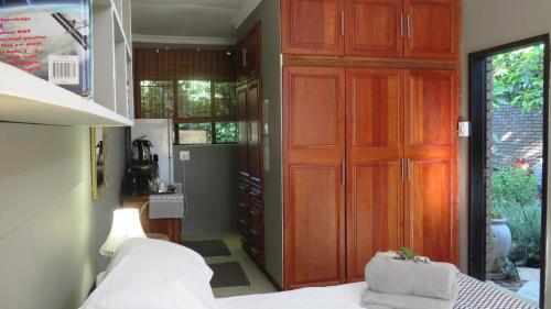 a bedroom with a large wooden closet and a bed at Beni Apartment in Pretoria