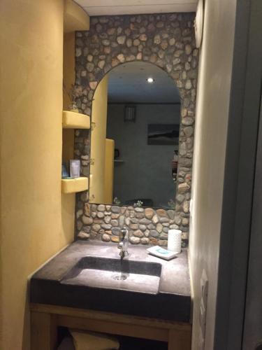 W łazience znajduje się umywalka i lustro. w obiekcie chambre d’hôtes des oliviers w mieście La Roque-sur-Cèze