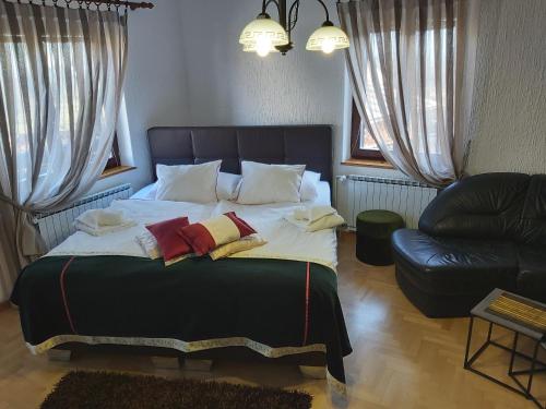 a bedroom with a large bed and a couch at Apartments & Rooms Florjana in Bled