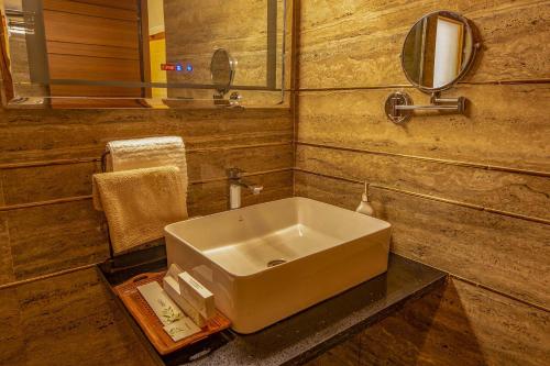 um banheiro com uma pia e um espelho em Golden Bliss Cottage by VEO - Part of StayVista em Rāmgarh