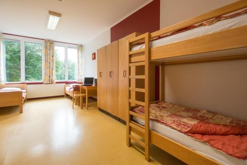 1 Schlafzimmer mit 2 Etagenbetten und einem Schreibtisch in der Unterkunft Atelier & Herberge ViDo in Burg-Reuland