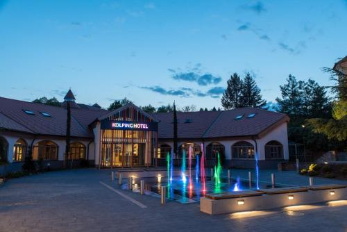 a building with a fountain in front of a building at Kolping Hotel Spa & Family Resort in Hévíz