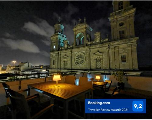an old building with a table and chairs in front of it at Santa Ana Suite & Rooms in Las Palmas de Gran Canaria