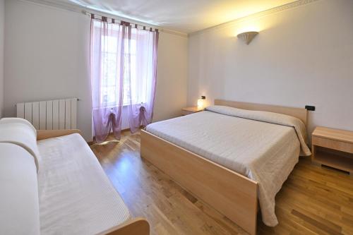 a bedroom with two beds and a window at Residenza Villa Maria in Roncola