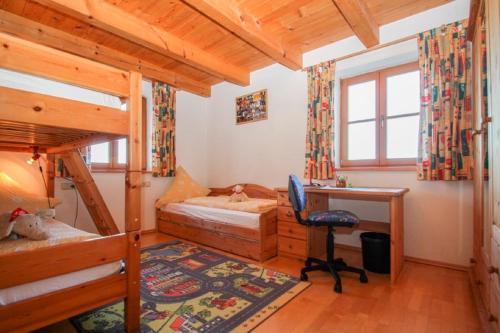 a bedroom with two bunk beds and a desk at Holzleitnerhof in Traunstein