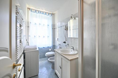Baño blanco con aseo y lavamanos en Residenza Villa Maria, en Roncola