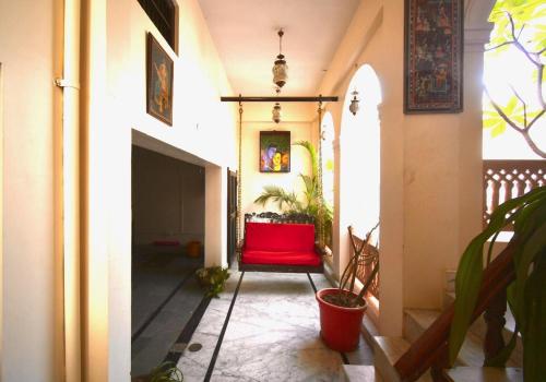 a hallway with a red chair in a house at Kanhaia Haveli in Pushkar