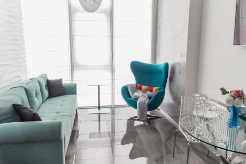 a living room with a blue couch and a glass table at Odesa Pearl Apartments in Odesa