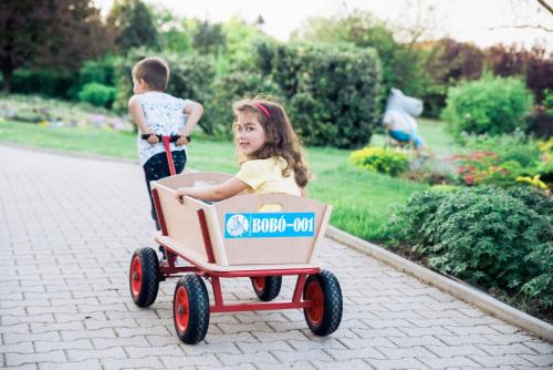 a little girl pushing a wagon with a little boy at Kolping Family Resort in Hévíz