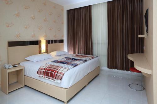 une chambre d'hôtel avec un lit et une fenêtre dans l'établissement Hotel Dewarna Sutoyo Malang, à Malang