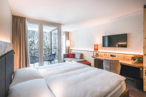 une chambre d'hôtel avec un lit et une télévision dans l'établissement Hotel Laudinella, à Saint-Moritz