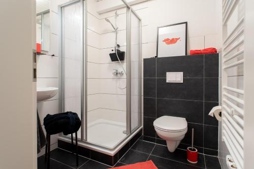 a bathroom with a shower and a toilet and a sink at Weberhof Ferienapartments in Rostrup am Westufer des Zwischenahner Meers in Bad Zwischenahn