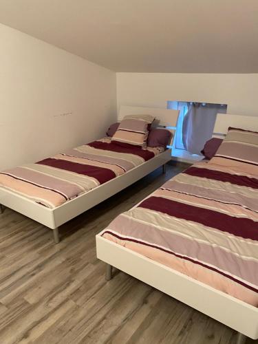 two beds sitting next to each other in a room at le pavillon pierre naturelle in Jaujac