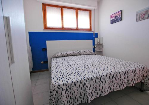 una camera con un letto con copriletto blu e bianco di LE MAREE EMATITE a Porto Azzurro