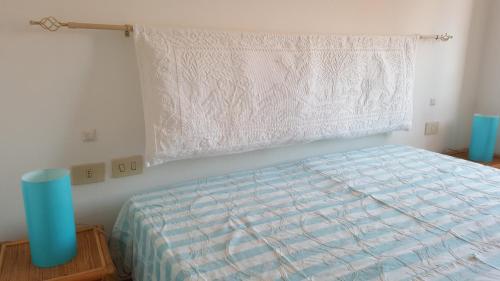 a bedroom with a bed and a window with a curtain at Residenze Coda Cavallo in San Teodoro