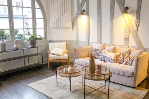 a living room with a couch and two tables at Logis Hôtel & Restaurant du Sauvage in La Ferté-Gaucher