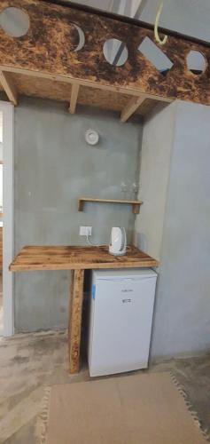 a kitchen with a wooden table and a refrigerator at Biktot Ba Arafel in Nimrod