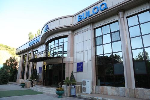 a building with a blue sign on the front of it at HUMSON BULOQ SANATORIUM in Khumson