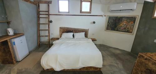 a bedroom with a large bed with white sheets at Biktot Ba Arafel in Nimrod