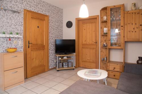 a kitchen with wooden cabinets and a tv in a room at Ferienwohnungen Wittmann, Wohnung 1.OG in Bad Staffelstein