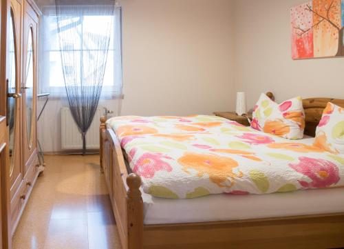 1 dormitorio con 1 cama con edredón de flores y ventana en Ferienwohnungen Wittmann, Wohnung 1.OG en Bad Staffelstein
