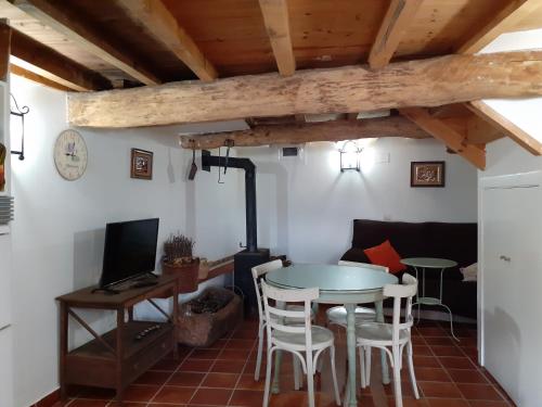 a living room with a table and chairs and a couch at Los Castaños in Solana de ávila