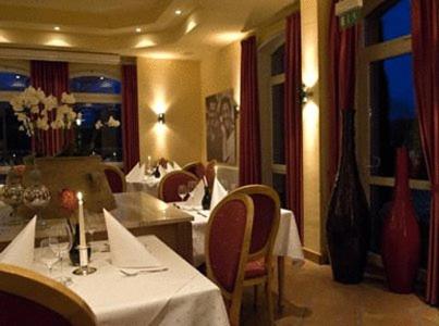 a restaurant with tables and chairs with white table cloth at AKZENT Hotel Altenberge in Altenberge