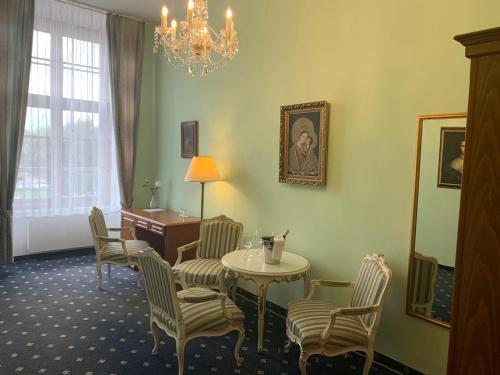 a room with a table and chairs and a desk at Wellness hotel Rezidence in Nové Hrady