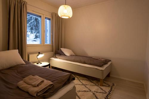 a bedroom with two beds and a window at Arctic Circle Holiday Homes in Rovaniemi