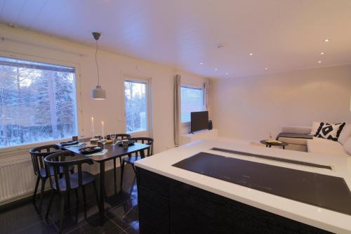 a kitchen and living room with a table and chairs at Arctic Circle Holiday Homes in Rovaniemi