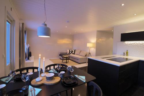 a kitchen and living room with a table and chairs at Arctic Circle Holiday Homes in Rovaniemi