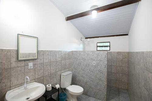 a bathroom with a sink and a toilet and a mirror at Pousada Bella Vida in Arraial d'Ajuda