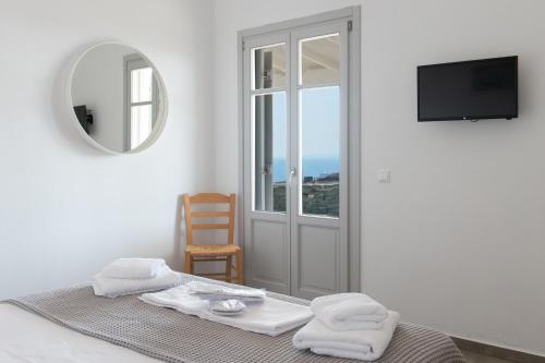 een slaapkamer met een bed met een spiegel en een raam bij Grey House in Exámbela