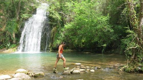 a man walking in front of a waterfall at Can Batlló, entorno acojedor y romántico in Molló
