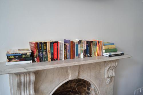 a fireplace with bookshelves filled with books at My Place Hotel in London