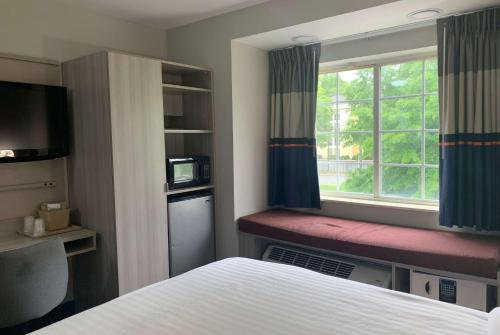 A bed or beds in a room at Microtel Inn by Wyndham Charlotte Airport