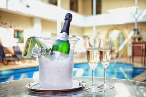 a bottle of champagne in a container on a table with two glasses at Wellness hotel Rezidence in Nové Hrady